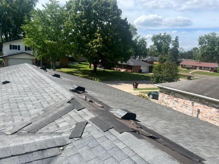 Wind-damaged ridge cap shingles found during a Dayton, Ohio roof inspection